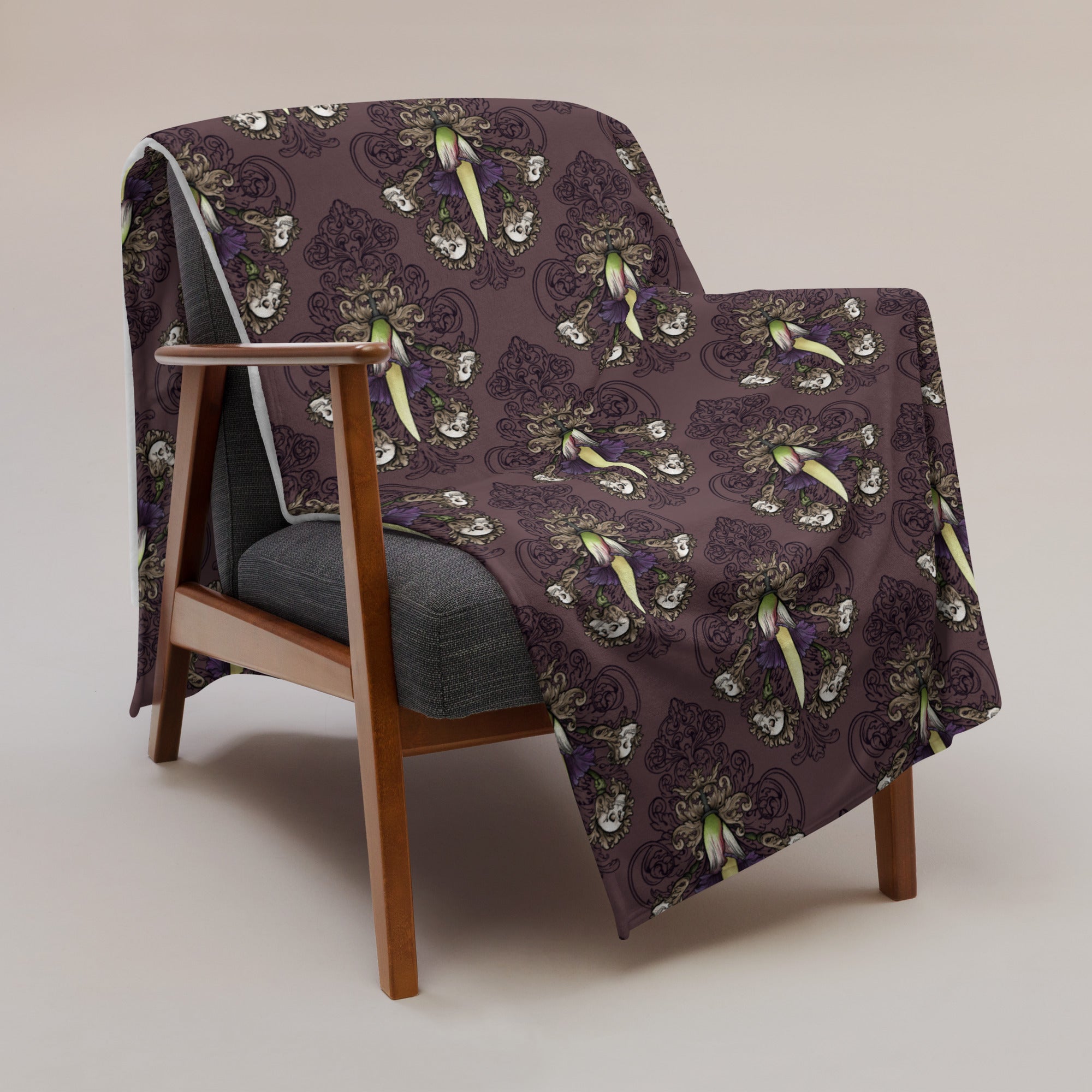 image of 60" x 80" Corpse flower blanket draped over a chair with repeated pattern of a corpse flower with skulls on filigree and dark, smokey, deep purple background